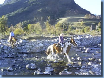 Riders crossing pitraco river  on a half day ride in Pucon, Chile